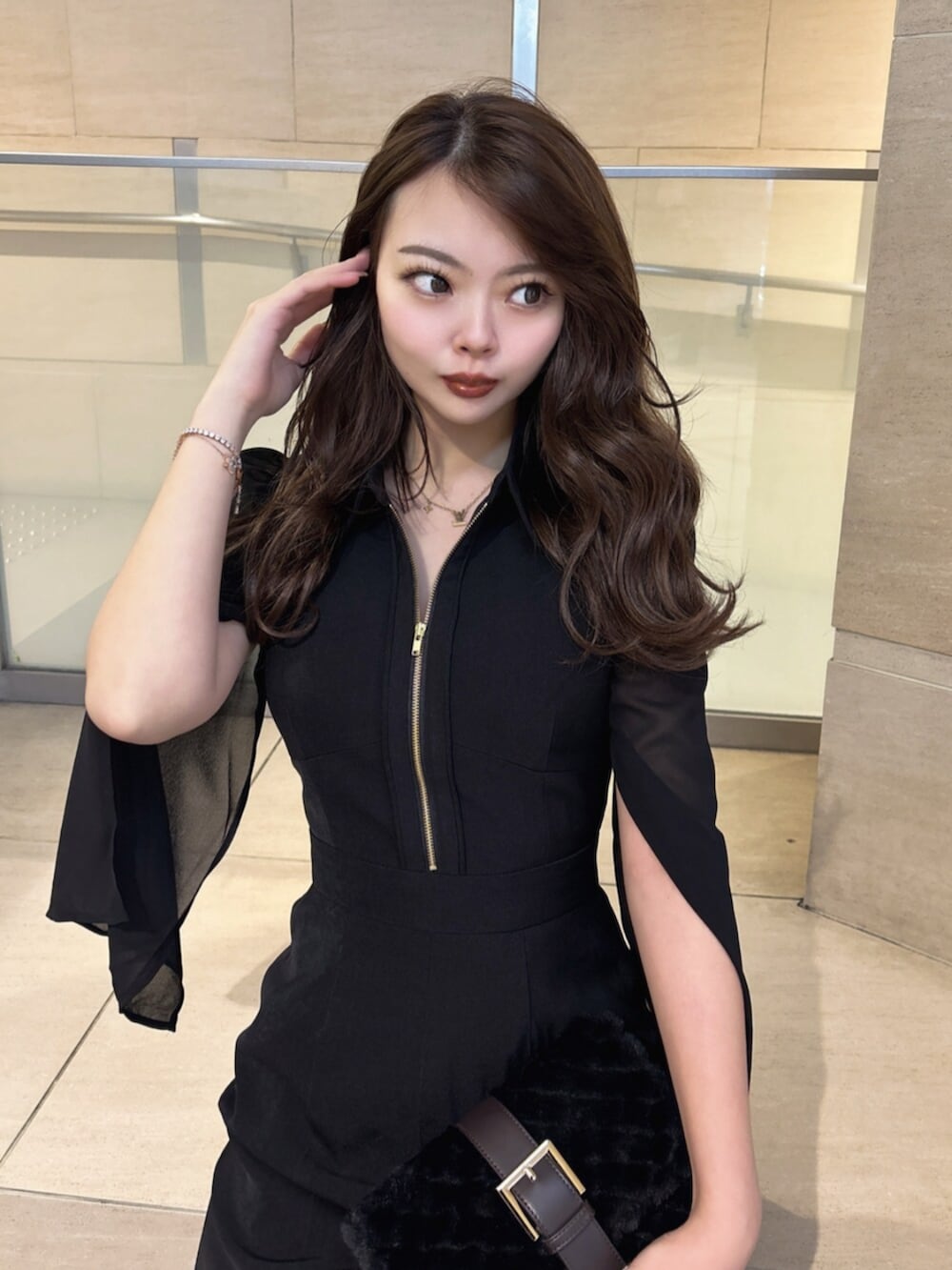 ブラック系のワンピース、ブラック系のハンドバッグ、ブラック系のパンプスを着用したレディースの冬コーディネートの6枚目の写真