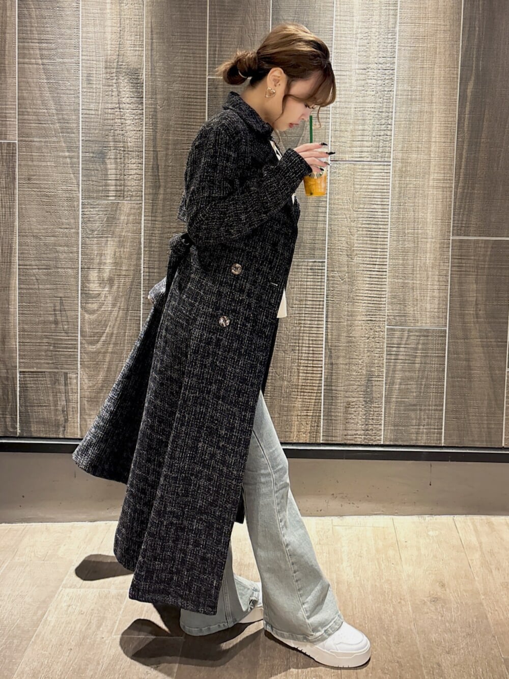 ホワイト系のニット/セーター、ブルー系のデニムパンツ、ブラック系のトレンチコートを着用したレディースの冬コーディネートの3枚目の写真