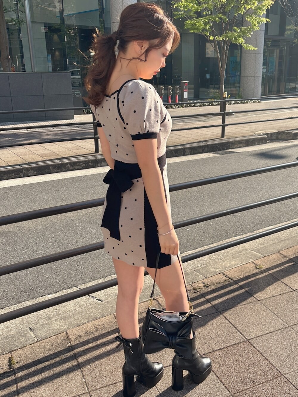 ブラック系のブーツ、ベージュ系のワンピースを着用したレディースの春コーディネートの6枚目の写真