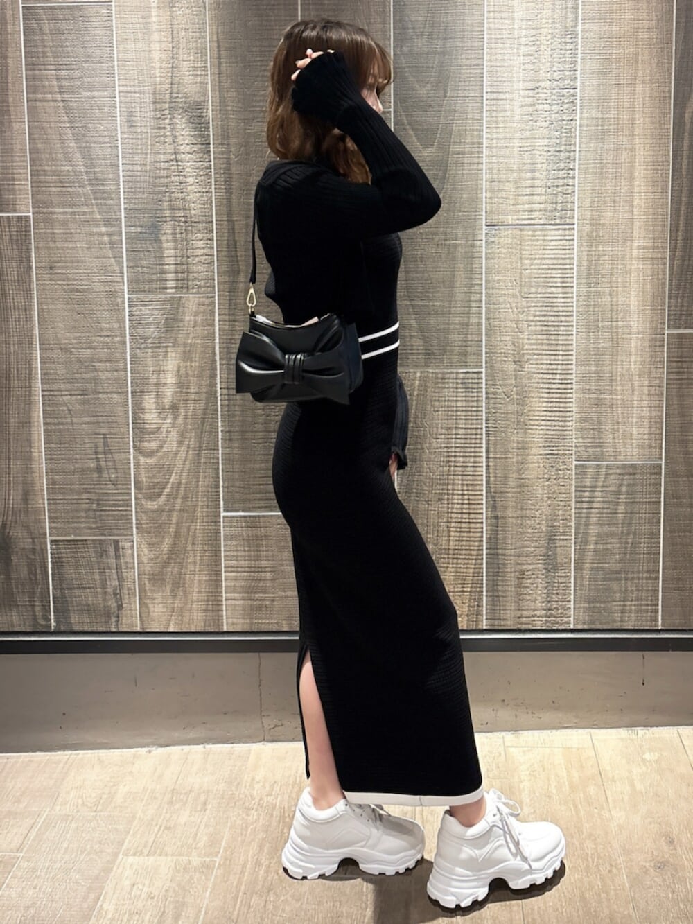 ブラック系のワンピース、ホワイト系のスニーカーを着用したレディースの春コーディネートの3枚目の写真