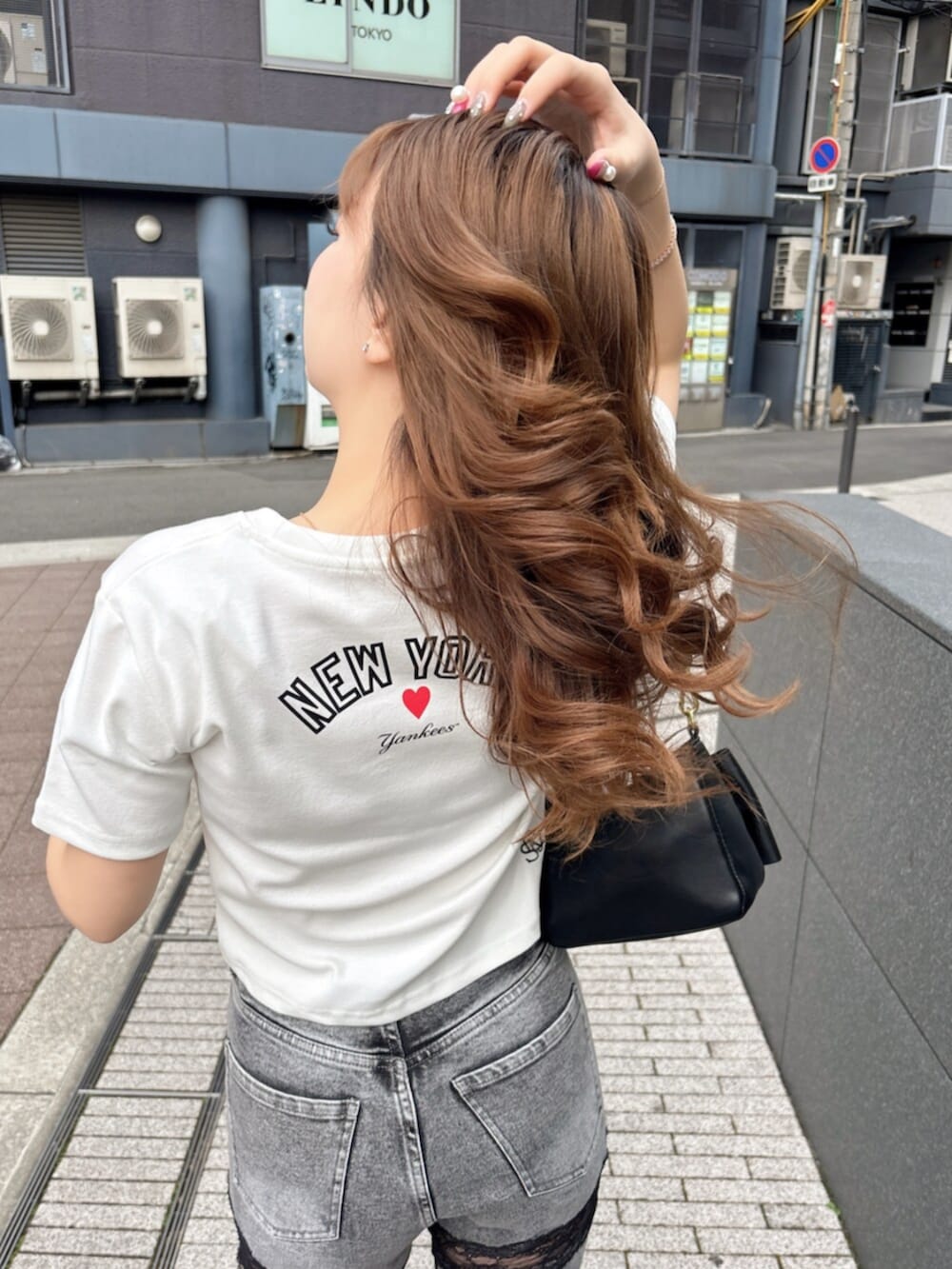 ホワイト系のTシャツ/カットソー、グレー系のデニムパンツ、ホワイト系のブーツを着用したレディースの春コーディネートの2枚目の写真