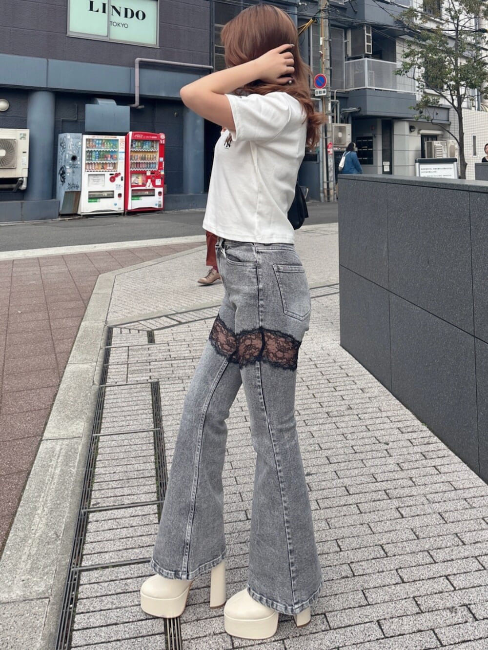 ホワイト系のTシャツ/カットソー、グレー系のデニムパンツ、ホワイト系のブーツを着用したレディースの春コーディネートの4枚目の写真