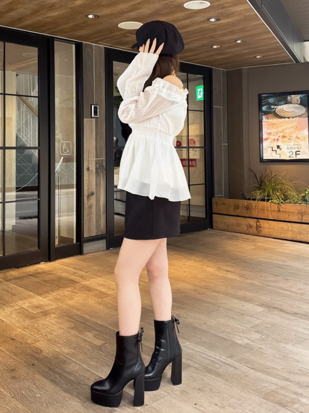 ブラック系のブーツ、ホワイト系のシャツ/ブラウス、ブラック系のスカートを着用したレディースの冬コーディネートの2枚目の写真