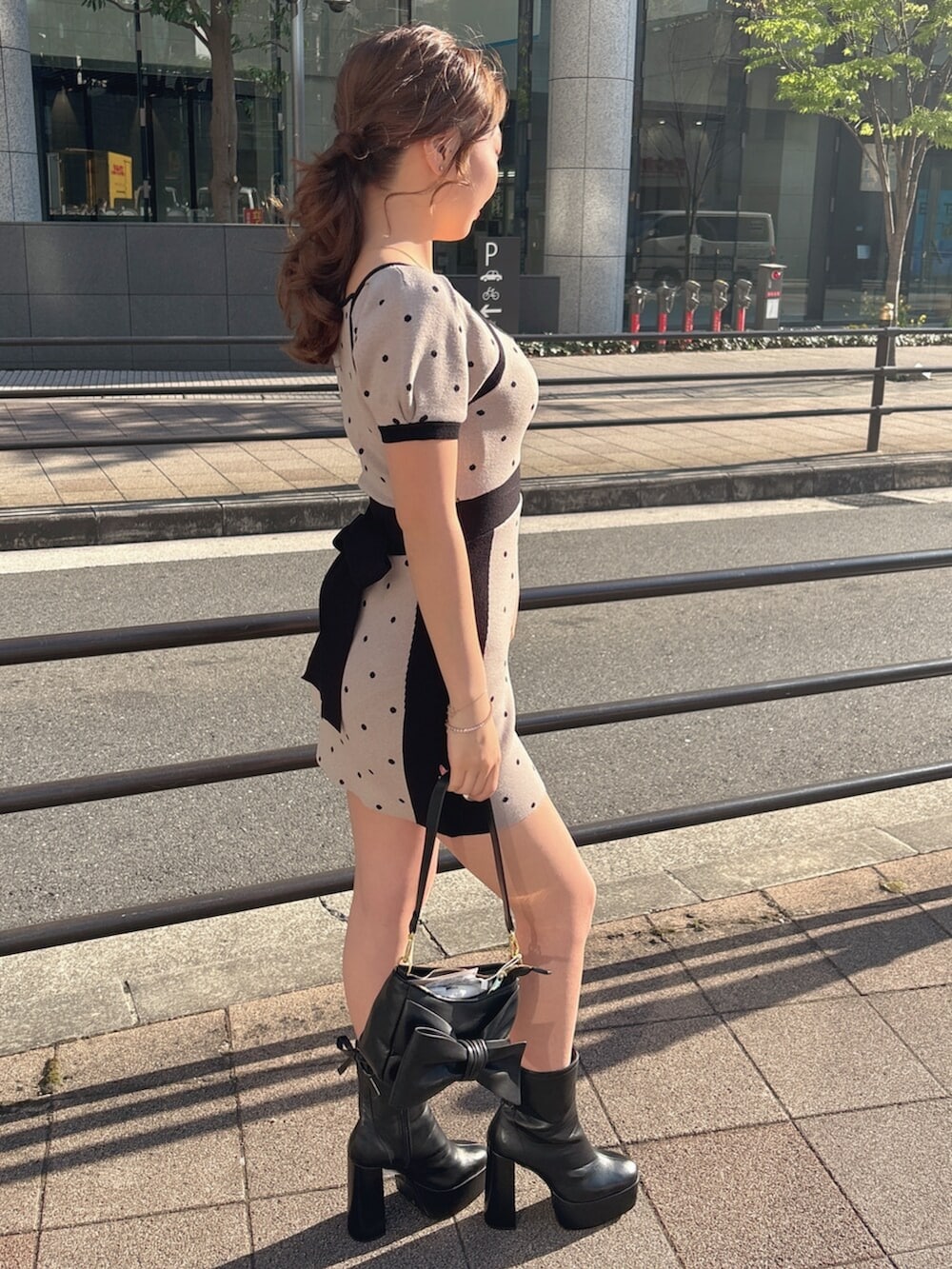 ブラック系のブーツ、ベージュ系のワンピースを着用したレディースの春コーディネートの7枚目の写真