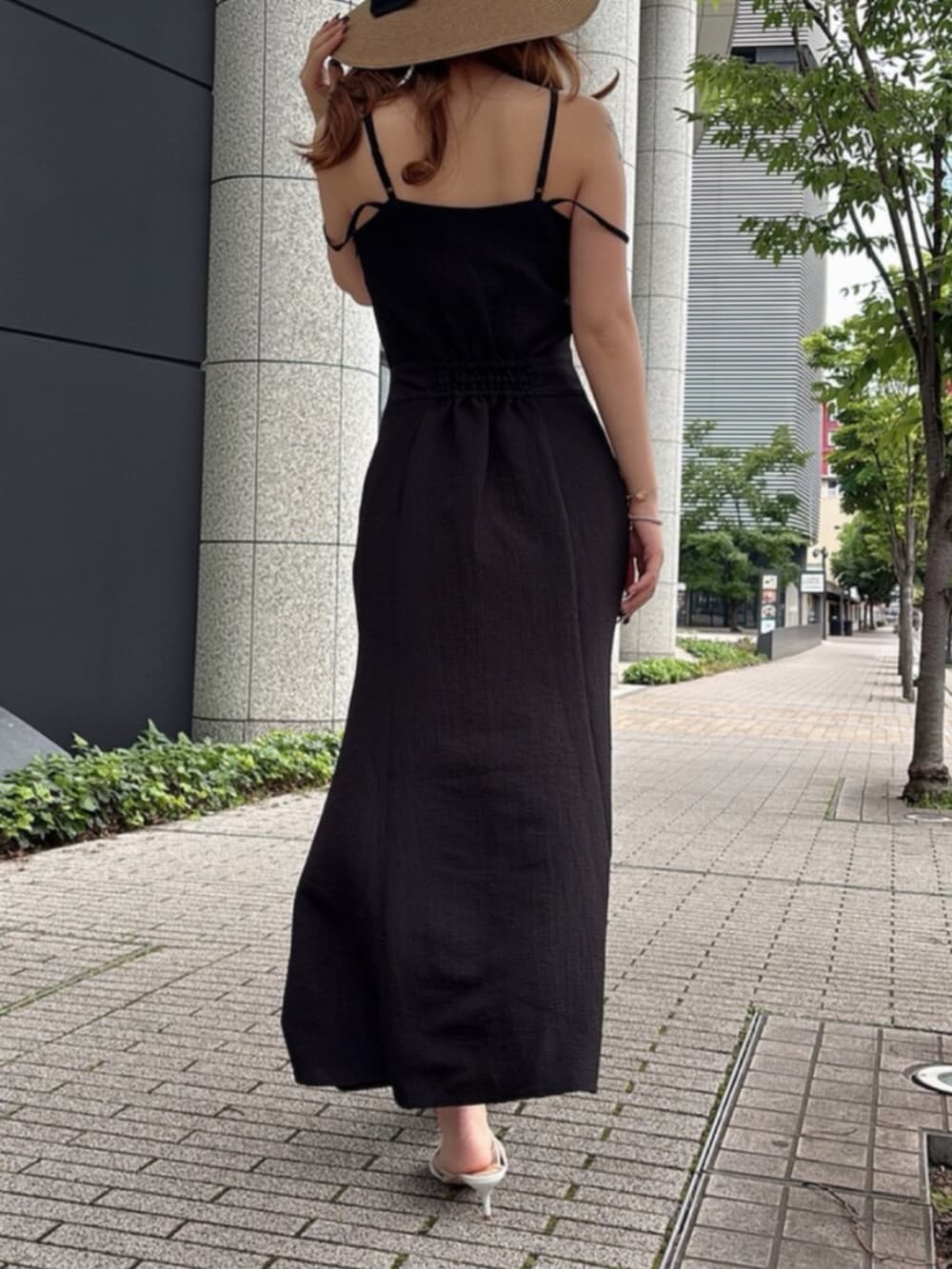ブラック系のワンピース、ホワイト系のサンダル、ブラウン系のハットを着用したレディースの夏コーディネートの2枚目の写真