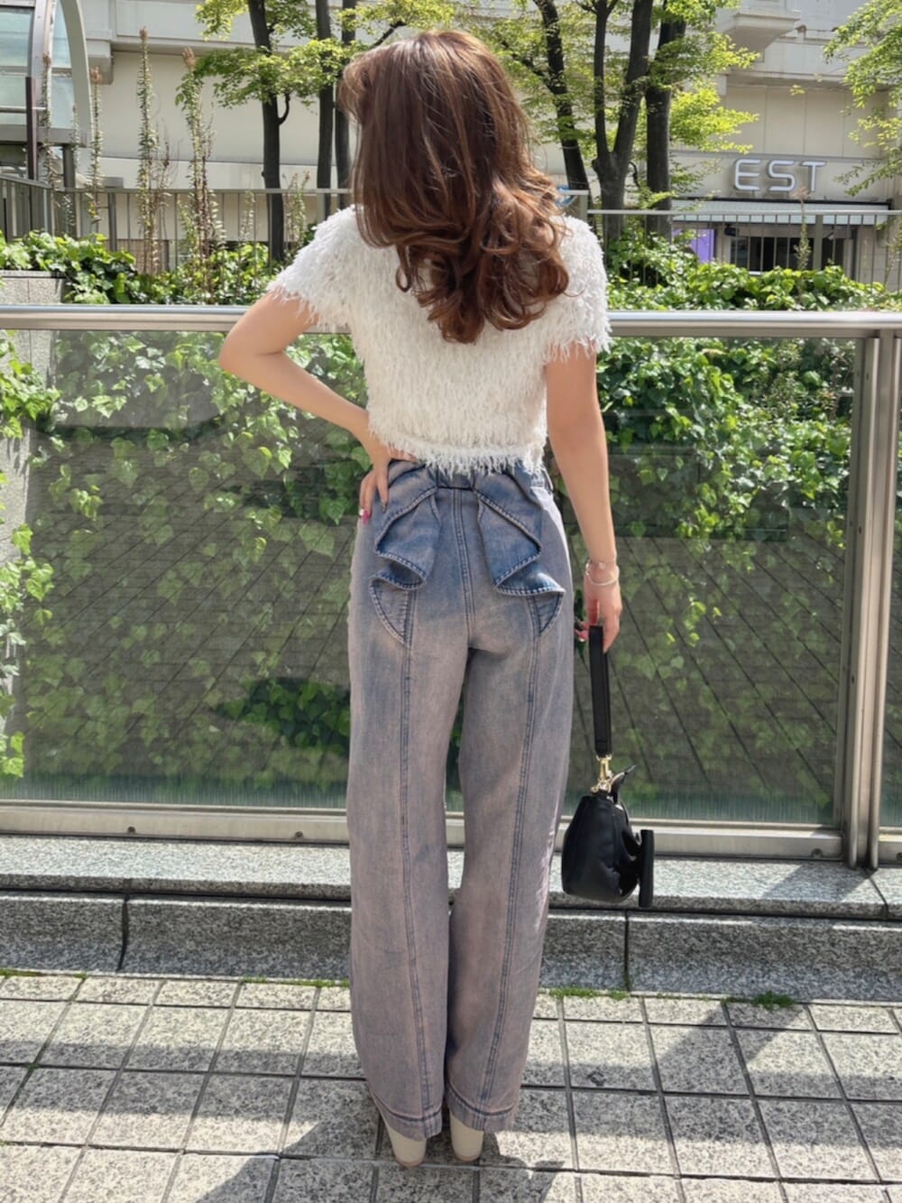 ホワイト系のTシャツ/カットソー、ピンク系のデニムパンツ、ホワイト系のサンダルを着用したレディースの春コーディネートの2枚目の写真