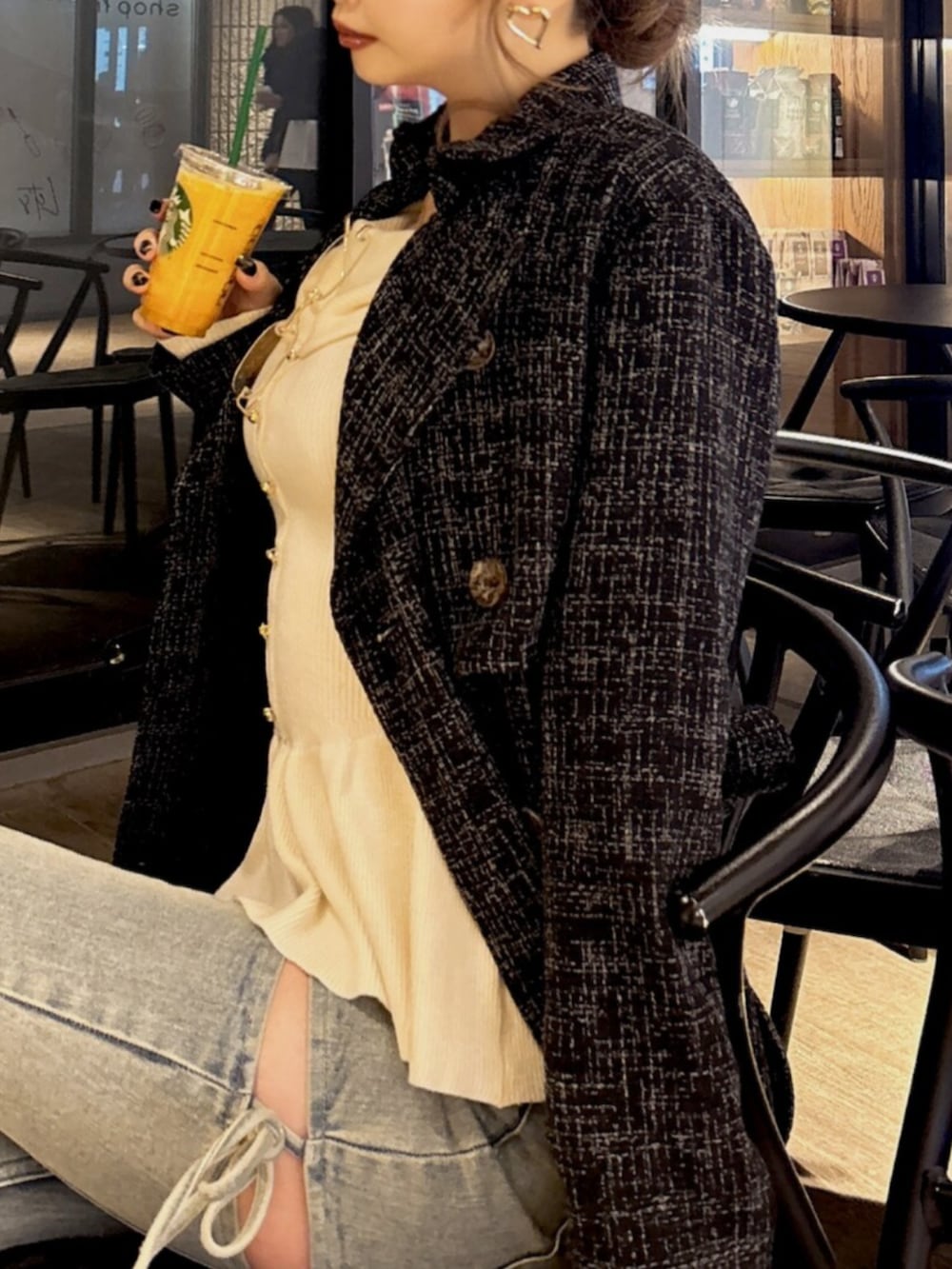 ホワイト系のニット/セーター、ブルー系のデニムパンツ、ブラック系のトレンチコートを着用したレディースの冬コーディネートの4枚目の写真