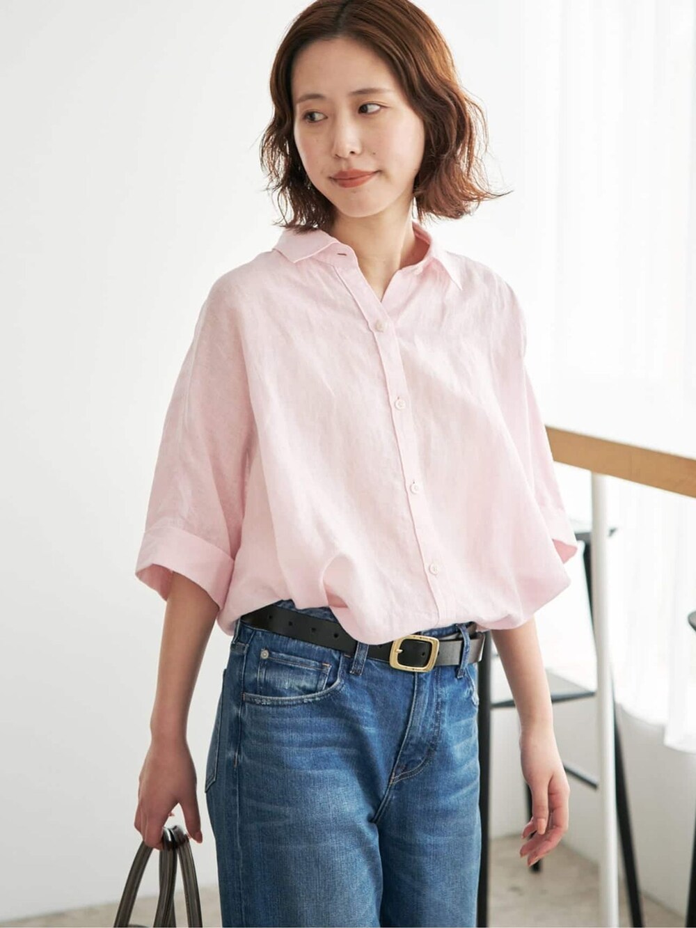 ブルー系のデニムパンツ、ピンク系のシャツ/ブラウス、ブラック系のトートバッグを着用したレディースの夏コーディネートの5枚目の写真
