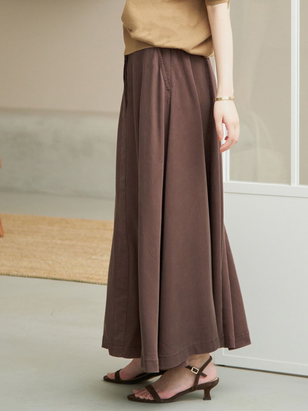 ブラウン系のスカート、ベージュ系のニット/セーター、ホワイト系のボストンバッグを着用したレディースの夏コーディネートの5枚目の写真