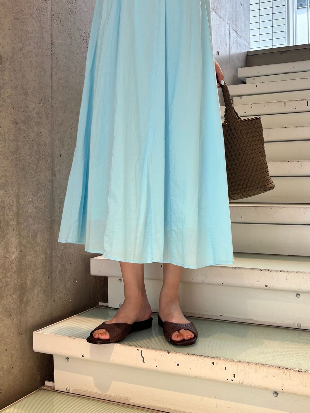 ブルー系のワンピース、ブラウン系のトートバッグ、ブラウン系のサンダルを着用したレディースの夏コーディネートの5枚目の写真