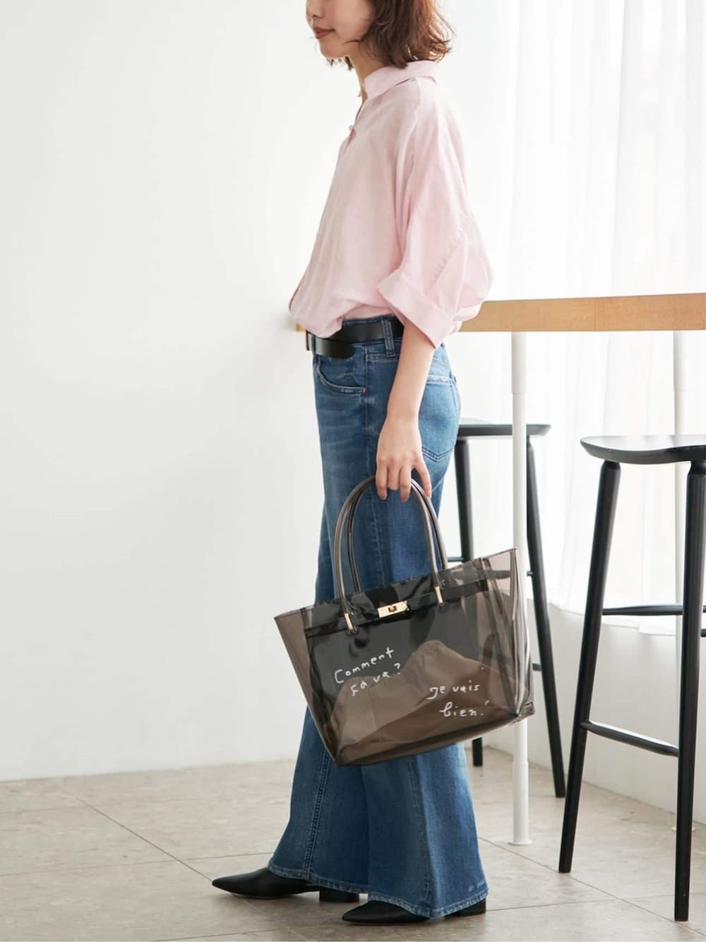 ブルー系のデニムパンツ、ピンク系のシャツ/ブラウス、ブラック系のトートバッグを着用したレディースの夏コーディネートの2枚目の写真
