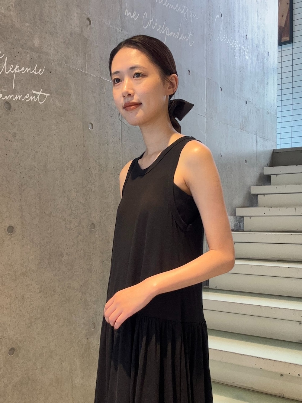 ブラック系のワンピース、ブラウン系のサンダルを着用したレディースの夏コーディネートの4枚目の写真