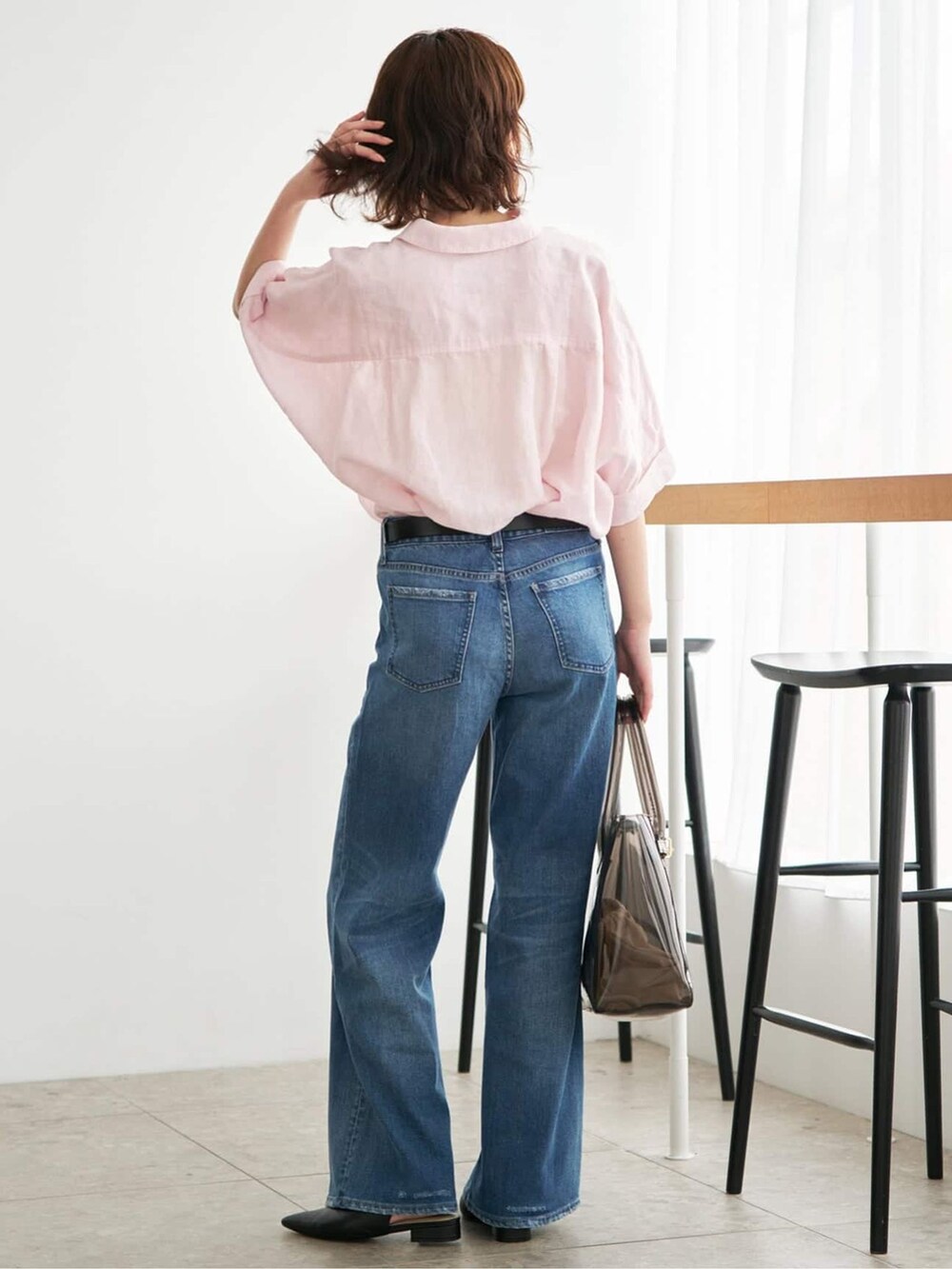 ブルー系のデニムパンツ、ピンク系のシャツ/ブラウス、ブラック系のトートバッグを着用したレディースの夏コーディネートの4枚目の写真