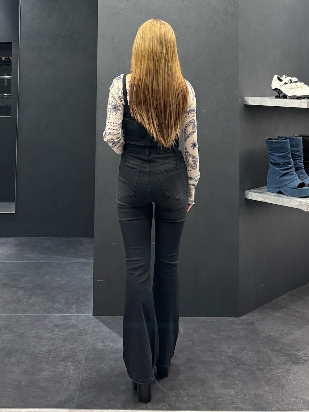 ブラック系のサロペット/オーバーオール、ホワイト系のTシャツ/カットソー、ブラック系のサンダルを着用したレディースの春コーディネートの3枚目の写真