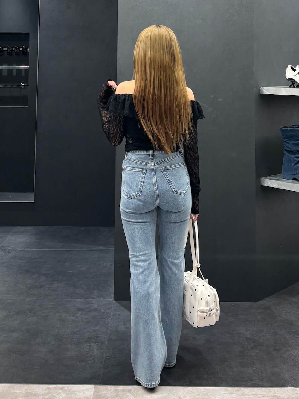 ブラック系のTシャツ/カットソー、ブルー系のデニムパンツ、ホワイト系のショルダーバッグを着用したレディースの春コーディネートの3枚目の写真