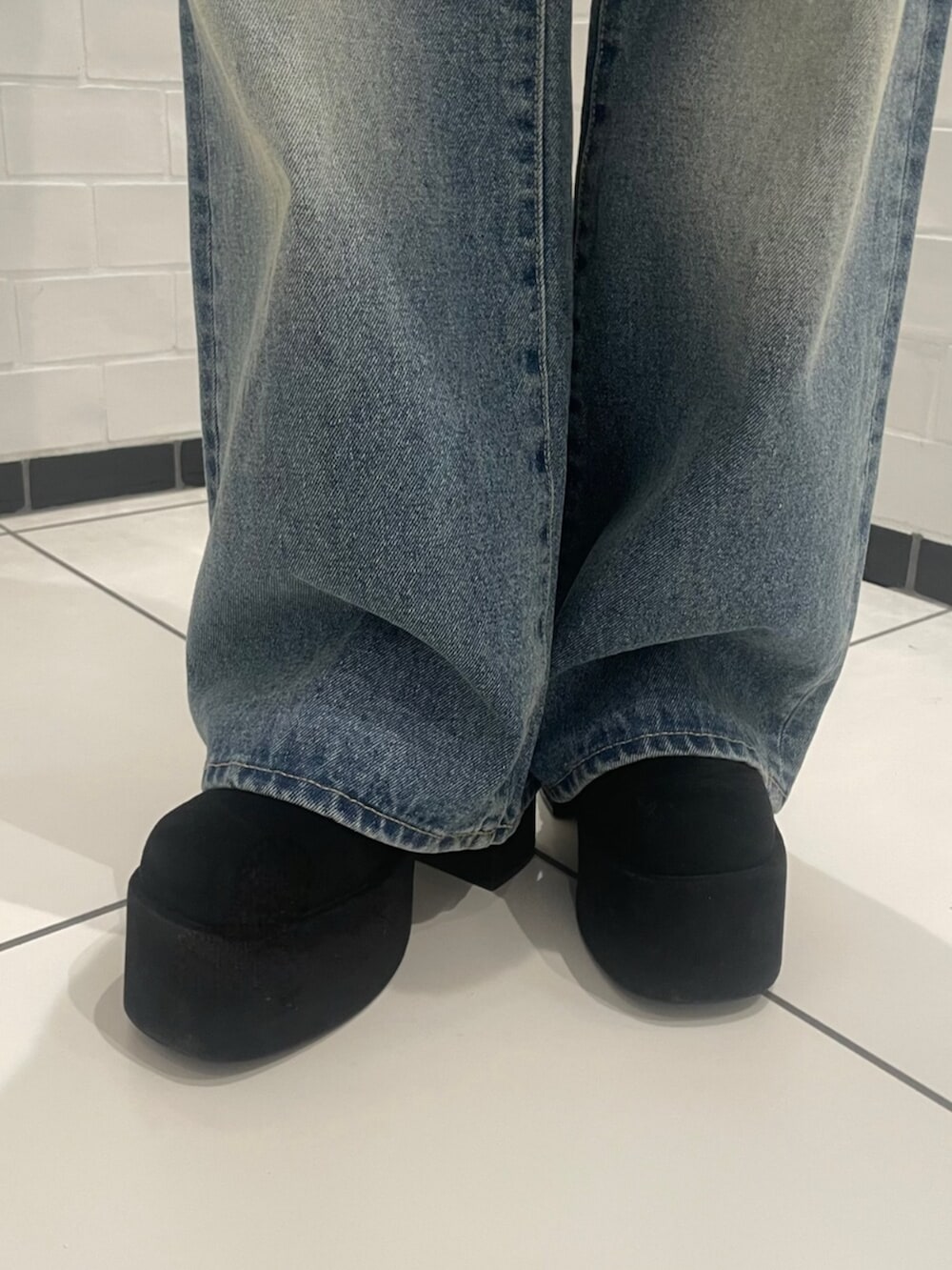 ブラウン系のニット/セーター、ブルー系のデニムパンツ、ブラック系のブーツを着用したレディースの冬コーディネートの7枚目の写真