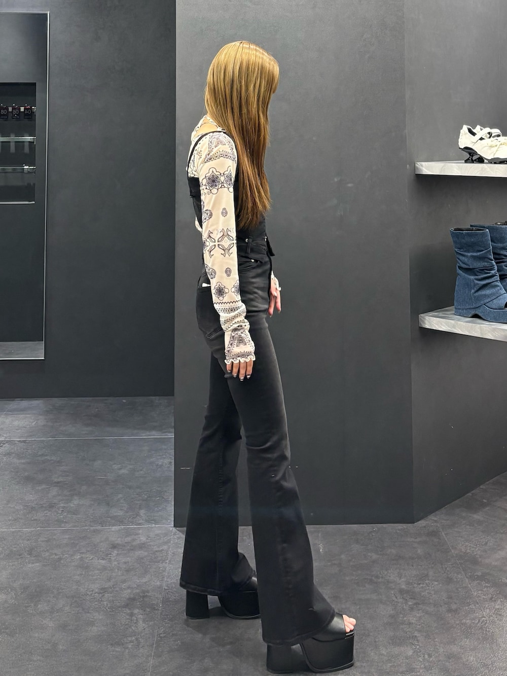 ブラック系のサロペット/オーバーオール、ホワイト系のTシャツ/カットソー、ブラック系のサンダルを着用したレディースの春コーディネートの2枚目の写真