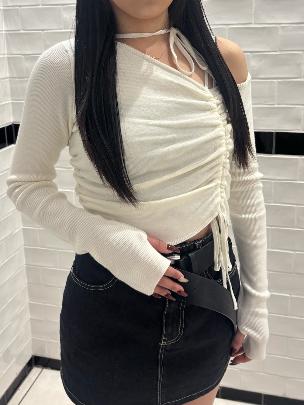 ホワイト系のニット/セーター、ブルー系のスカート、ブラック系のブーツを着用したレディースの冬コーディネートの5枚目の写真