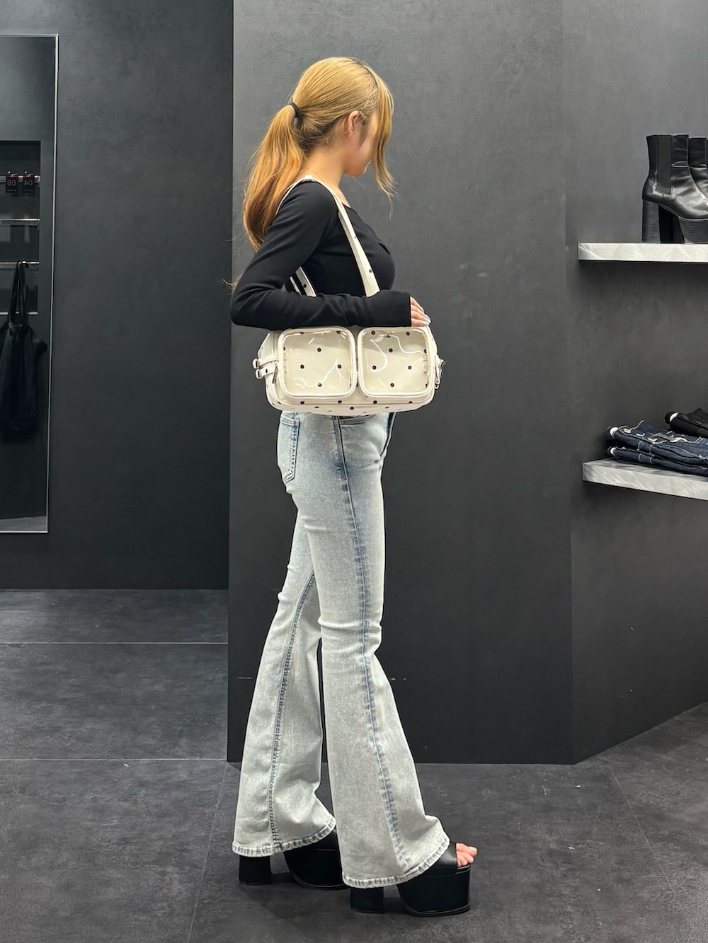 ブラック系のTシャツ/カットソー、ブルー系のデニムパンツ、ブラック系のサンダルを着用したレディースの春コーディネートの2枚目の写真