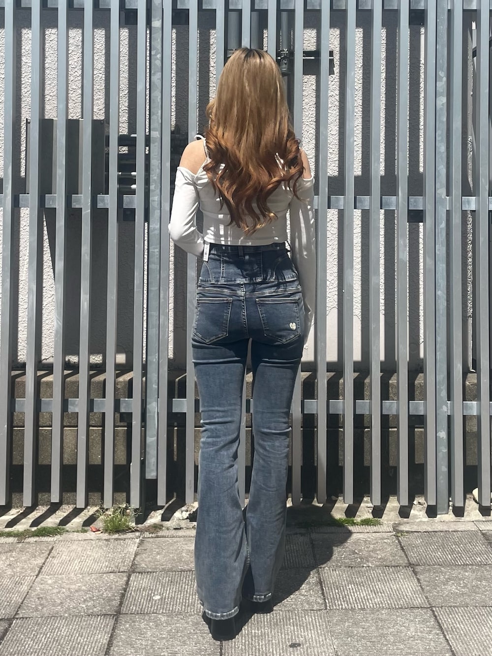 ホワイト系のTシャツ/カットソー、ブルー系のデニムパンツ、ブラック系のサンダルを着用したレディースの春コーディネートの3枚目の写真