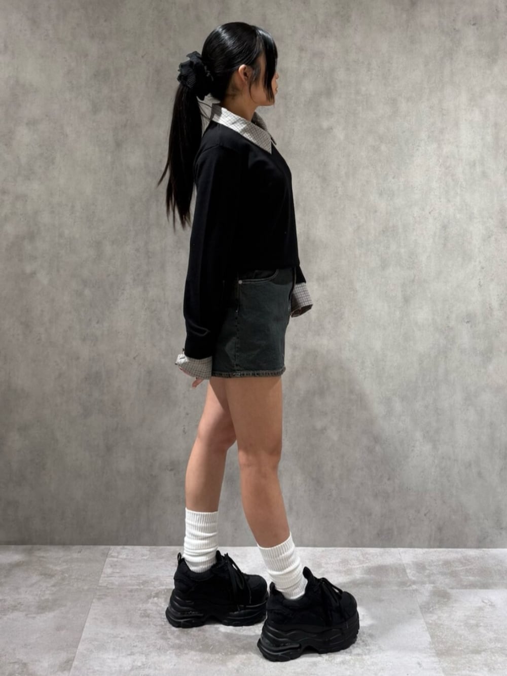 ブラック系のスニーカー、ブラック系のシャツ/ブラウス、ブルー系のスカートを着用したレディースの冬コーディネートの2枚目の写真