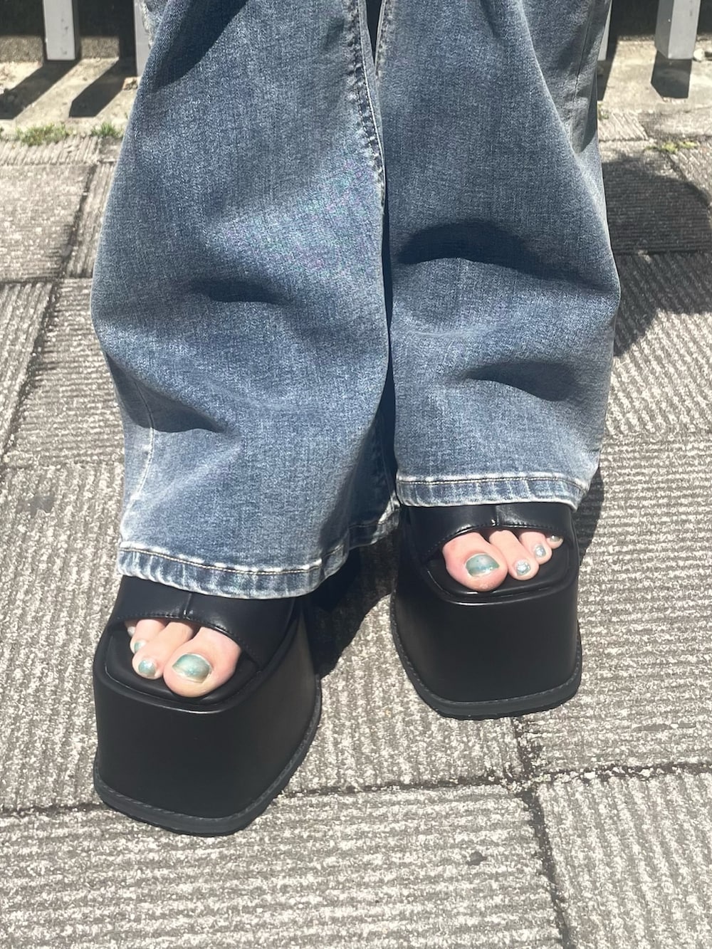 ホワイト系のTシャツ/カットソー、ブルー系のデニムパンツ、ブラック系のサンダルを着用したレディースの春コーディネートの6枚目の写真