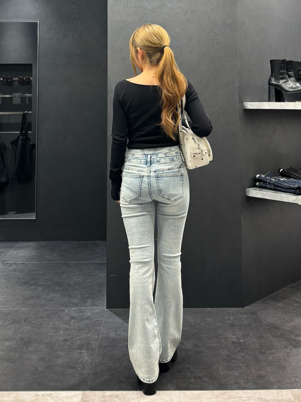 ブラック系のTシャツ/カットソー、ブルー系のデニムパンツ、ブラック系のサンダルを着用したレディースの春コーディネートの3枚目の写真