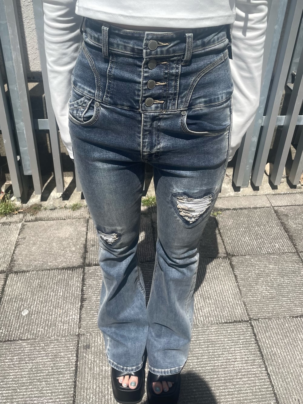 ホワイト系のTシャツ/カットソー、ブルー系のデニムパンツ、ブラック系のサンダルを着用したレディースの春コーディネートの5枚目の写真