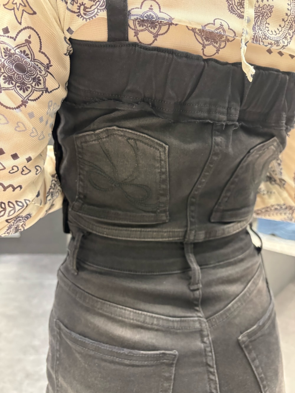 ブラック系のサロペット/オーバーオール、ホワイト系のTシャツ/カットソー、ブラック系のサンダルを着用したレディースの春コーディネートの4枚目の写真