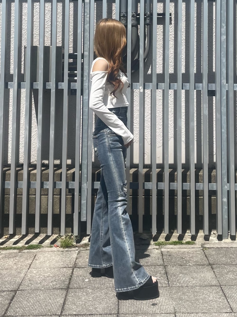 ホワイト系のTシャツ/カットソー、ブルー系のデニムパンツ、ブラック系のサンダルを着用したレディースの春コーディネートの2枚目の写真