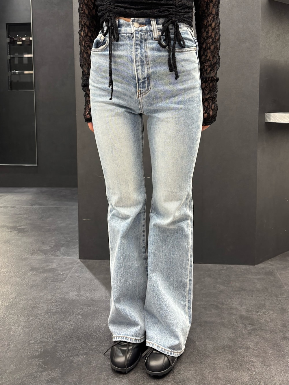 ブラック系のTシャツ/カットソー、ブルー系のデニムパンツ、ホワイト系のショルダーバッグを着用したレディースの春コーディネートの5枚目の写真