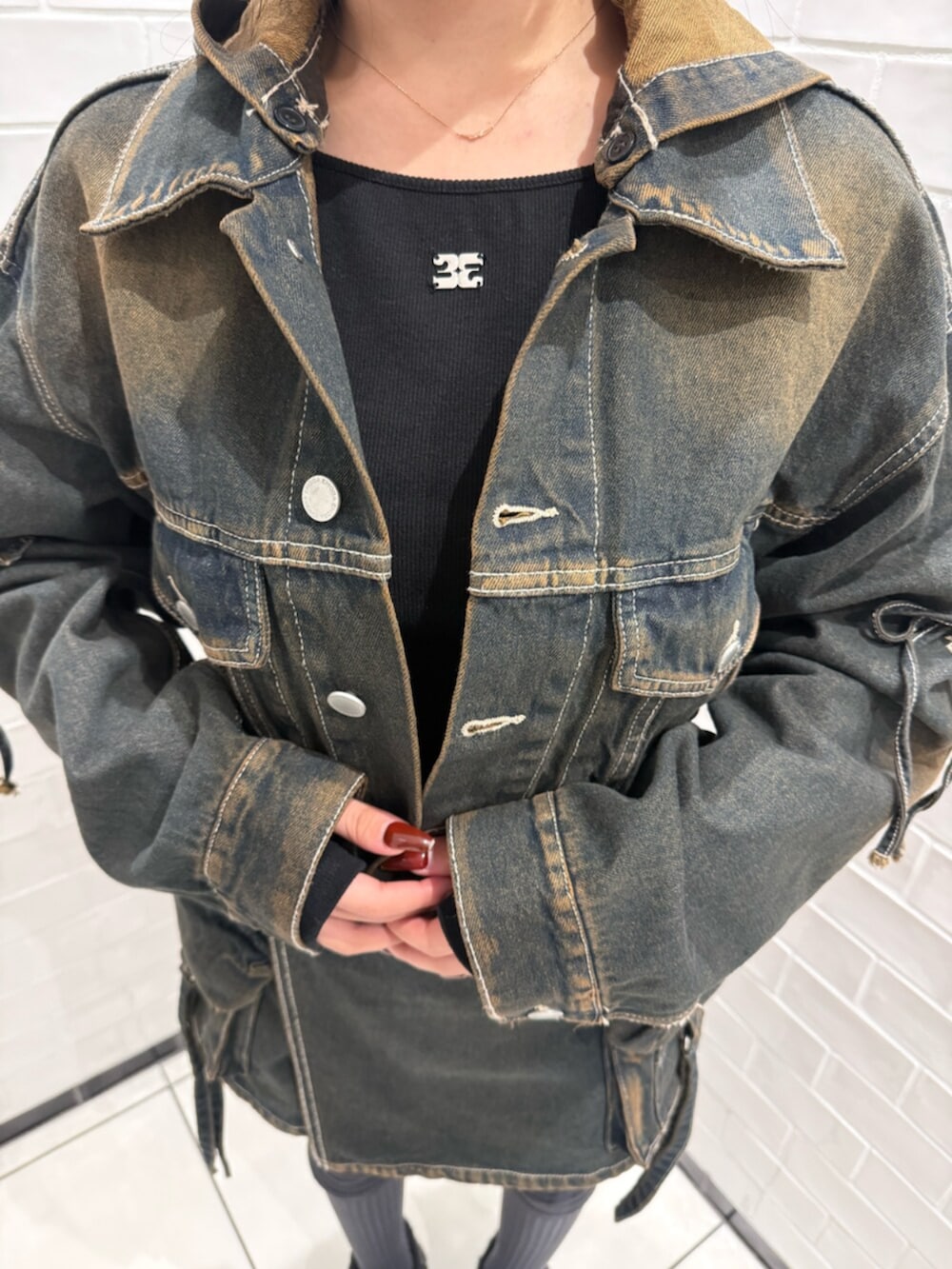 ブラック系のスニーカー、ブルー系のデニムジャケット、ブルー系のその他パンツを着用したレディースの冬コーディネートの4枚目の写真