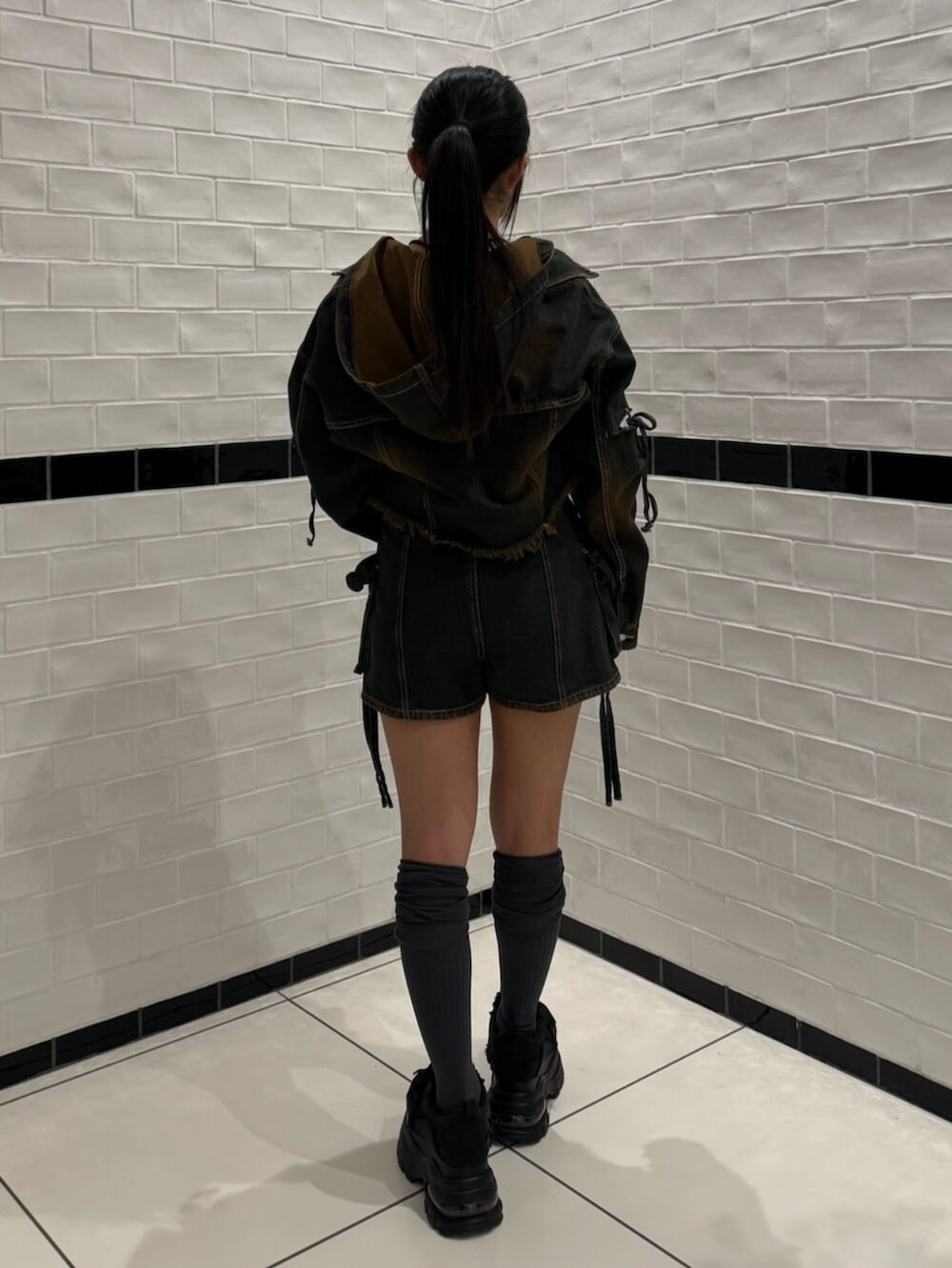 ブラック系のスニーカー、ブルー系のデニムジャケット、ブルー系のその他パンツを着用したレディースの冬コーディネートの3枚目の写真