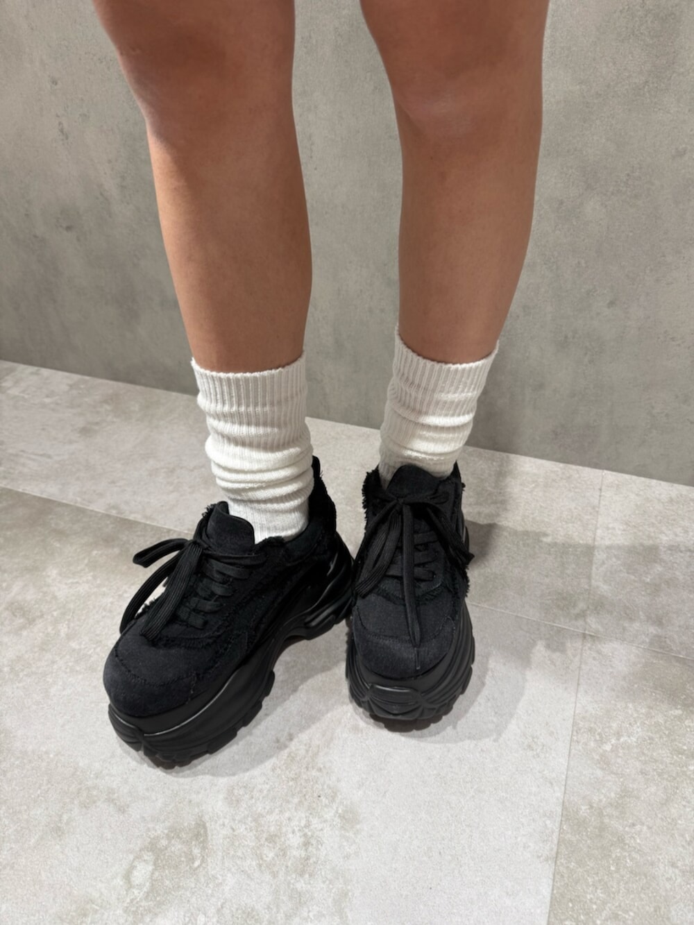 ブラック系のスニーカー、ブラック系のシャツ/ブラウス、ブルー系のスカートを着用したレディースの冬コーディネートの6枚目の写真