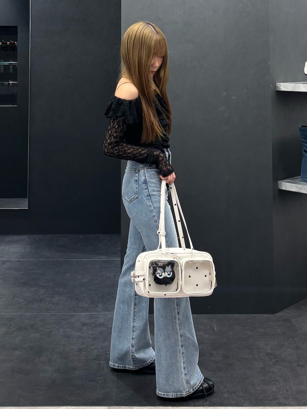 ブラック系のTシャツ/カットソー、ブルー系のデニムパンツ、ホワイト系のショルダーバッグを着用したレディースの春コーディネートの2枚目の写真