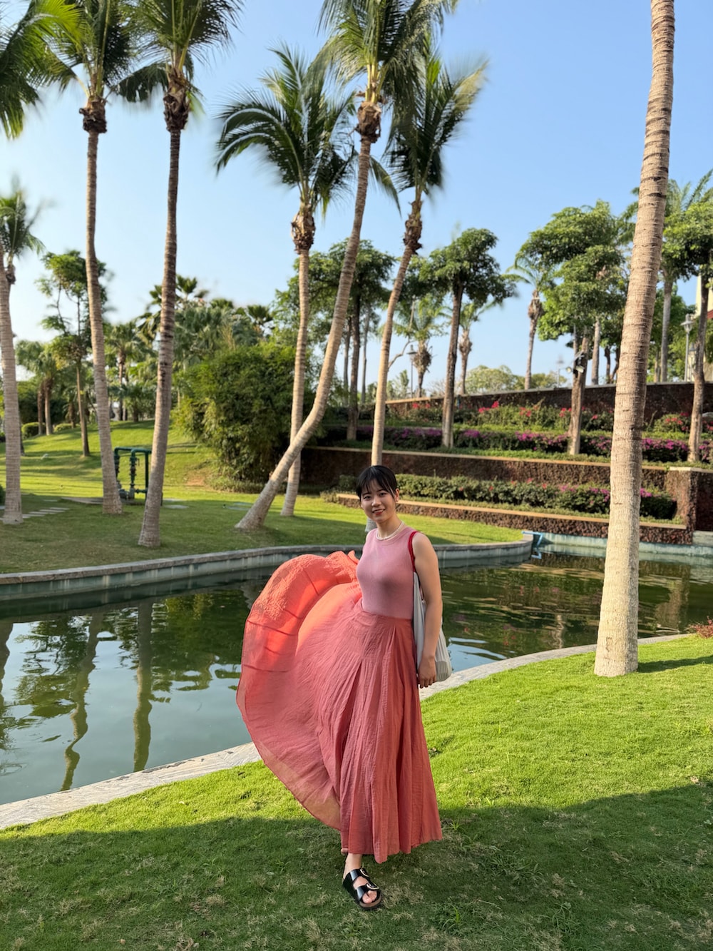 ピンク系のジャンパースカート、ブラック系のサンダルを着用したレディースの冬コーディネートの2枚目の写真