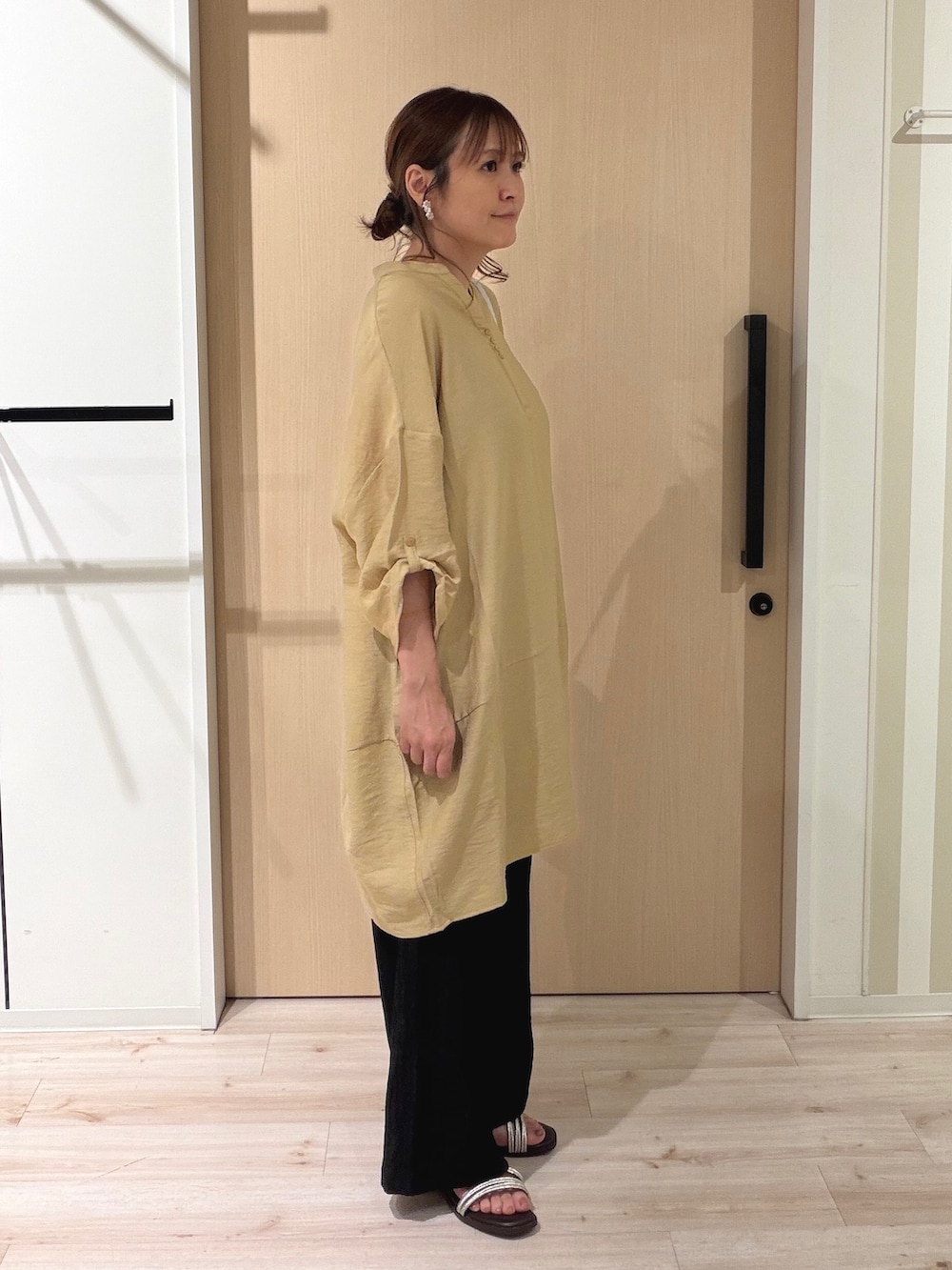 イエロー系のワンピース、ブラック系のその他パンツ、ブラウン系のサンダルを着用したレディースの夏コーディネートの4枚目の写真
