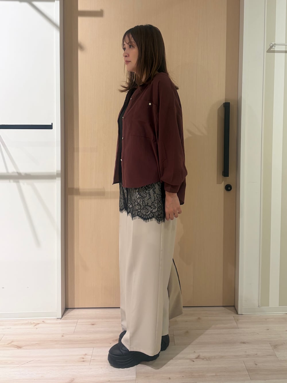 レッド系のシャツ/ブラウス、ブラック系のタンクトップ、ベージュ系のその他パンツを着用したレディースの秋コーディネートの2枚目の写真