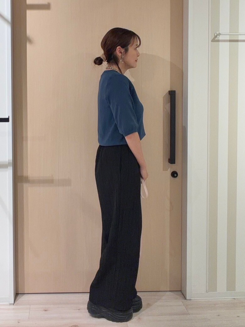 ブルー系のニット/セーター、ブラック系のその他パンツ、ピンク系のショルダーバッグを着用したレディースの秋コーディネートの4枚目の写真