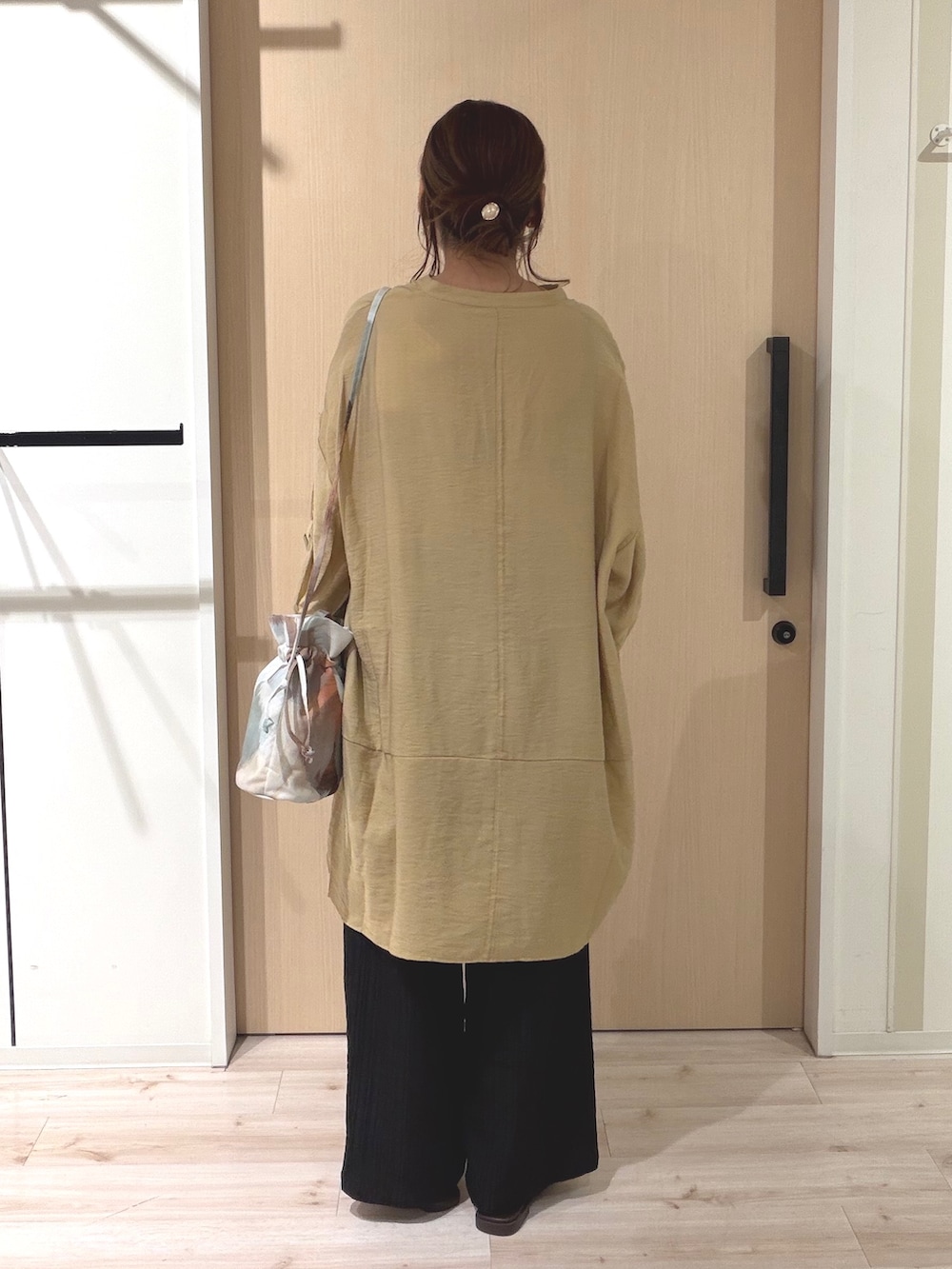 イエロー系のワンピース、ブラック系のその他パンツ、ブラウン系のサンダルを着用したレディースの夏コーディネートの3枚目の写真