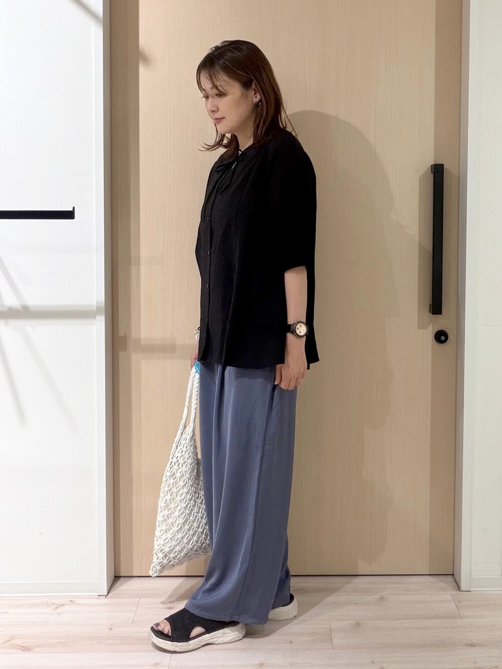 ブラック系のシャツ/ブラウス、ブルー系のその他パンツ、ホワイト系のトートバッグを着用したレディースの夏コーディネートの2枚目の写真