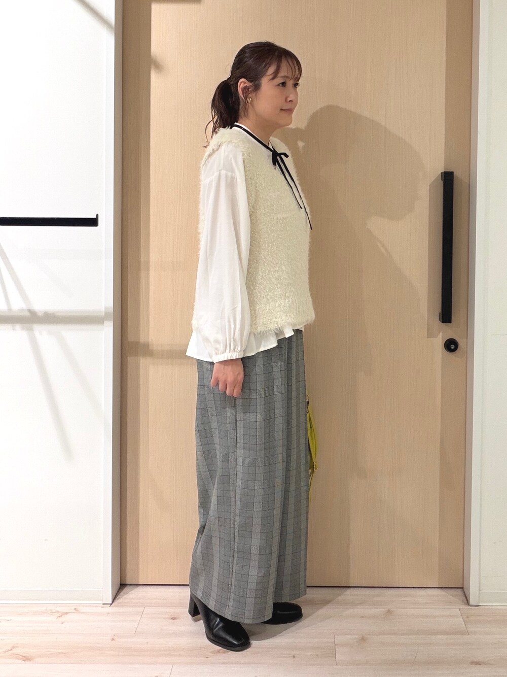 ホワイト系のベスト、ホワイト系のシャツ/ブラウス、グレー系のその他パンツを着用したレディースの秋コーディネートの4枚目の写真