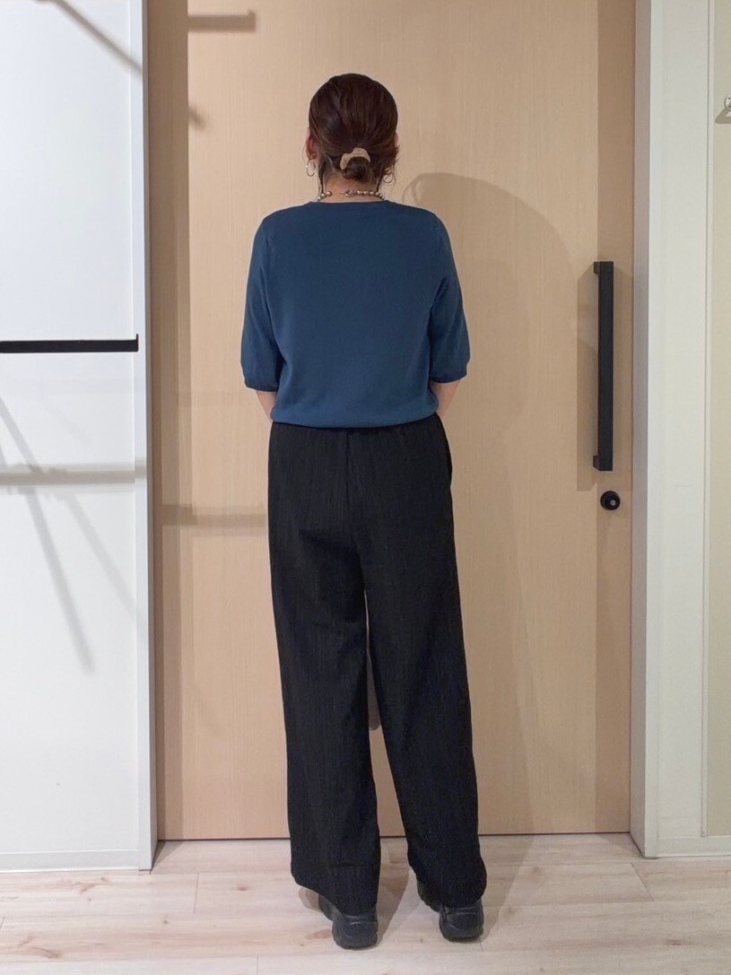 ブルー系のニット/セーター、ブラック系のその他パンツ、ピンク系のショルダーバッグを着用したレディースの秋コーディネートの3枚目の写真