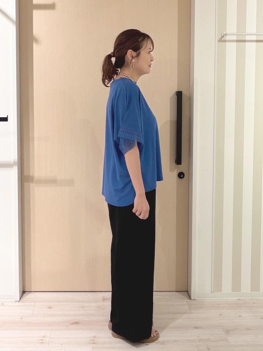 ブルー系のTシャツ/カットソー、ブラック系のその他パンツ、ブラウン系のサンダルを着用したレディースの夏コーディネートの4枚目の写真