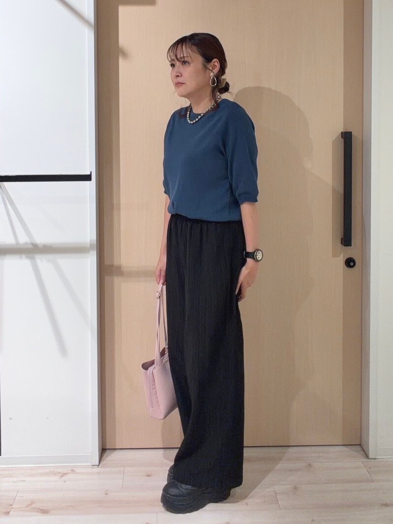 ブルー系のニット/セーター、ブラック系のその他パンツ、ピンク系のショルダーバッグを着用したレディースの秋コーディネートの2枚目の写真