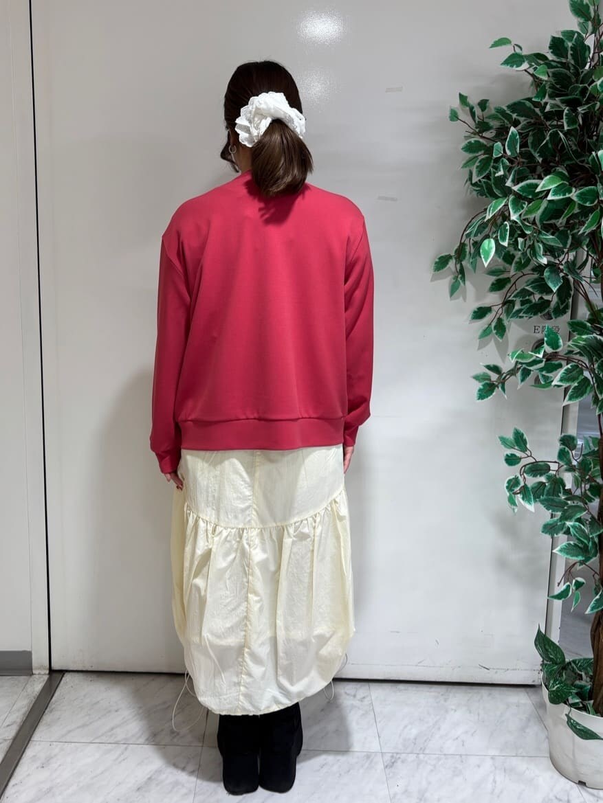 レッド系のブルゾン、ホワイト系のスカート、ブラック系のニット/セーターを着用したレディースの春コーディネートの3枚目の写真