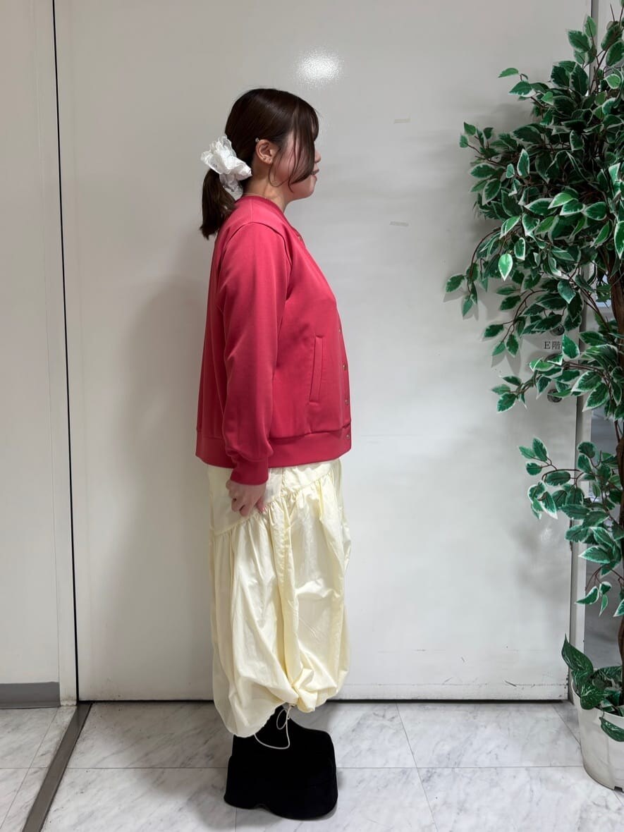 レッド系のブルゾン、ホワイト系のスカート、ブラック系のニット/セーターを着用したレディースの春コーディネートの2枚目の写真