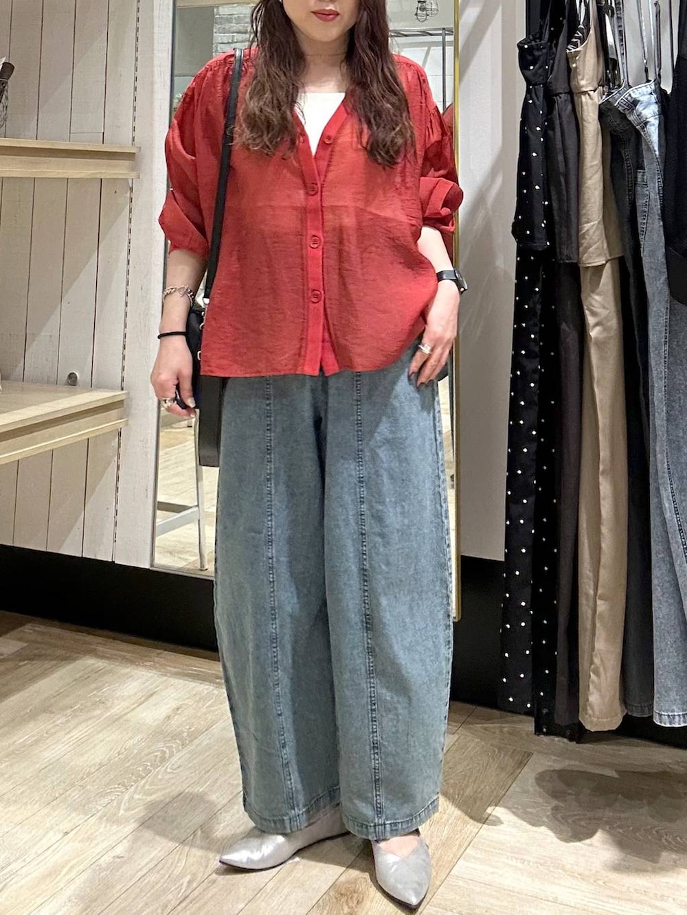 シルバー系のパンプス、レッド系のシャツ/ブラウス、ブラック系のショルダーバッグを着用したレディースの春コーディネートの5枚目の写真