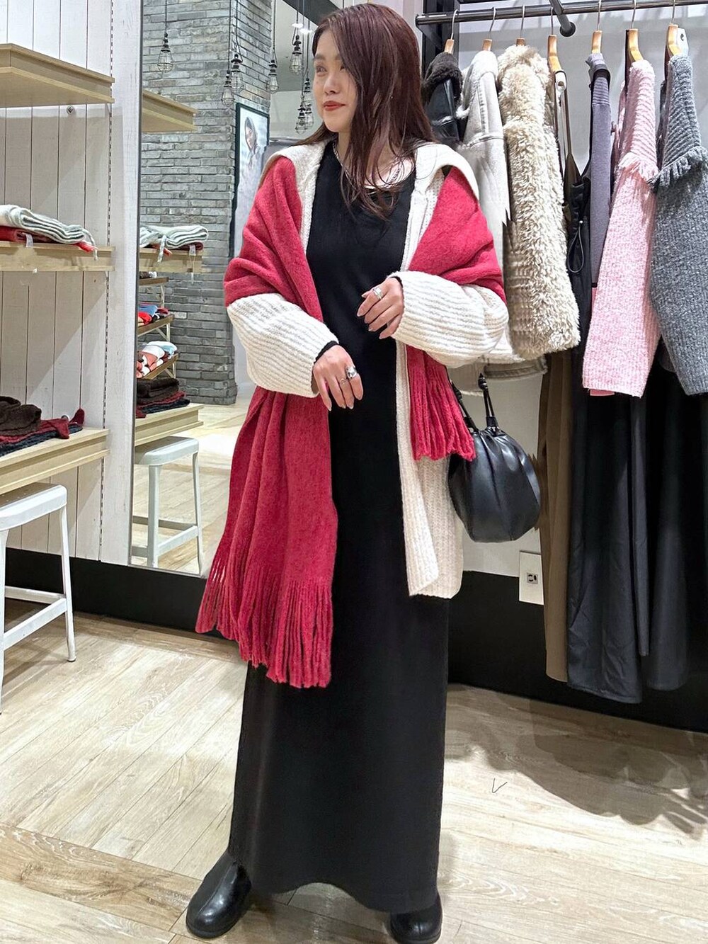 ブラック系のブーツ、ブラック系のショルダーバッグ、ブラック系のワンピースを着用したレディースの秋コーディネートの5枚目の写真