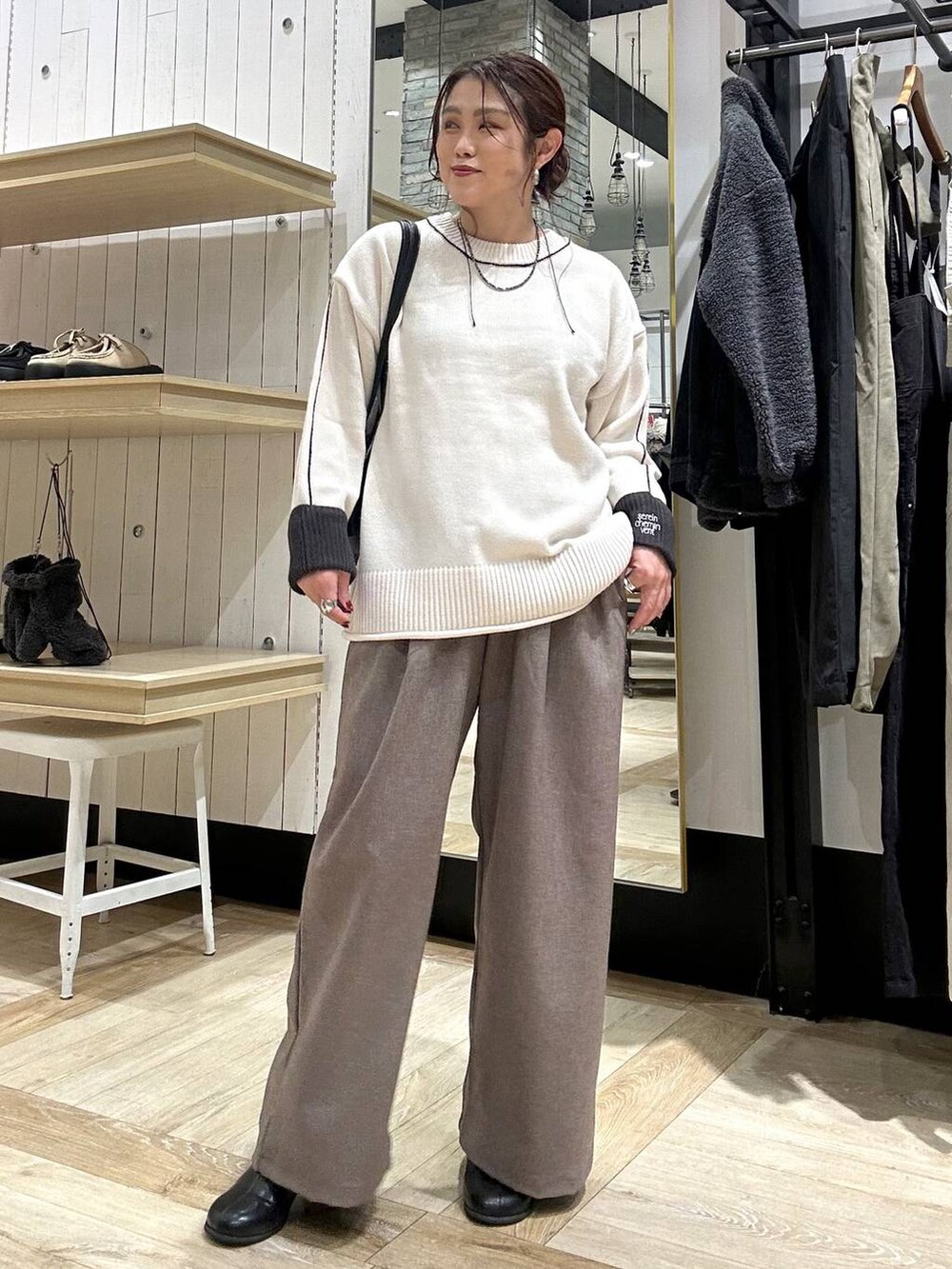 ブラック系のボストンバッグ、ブラック系のブーツ、ブラウン系のその他パンツを着用したレディースの冬コーディネートの5枚目の写真